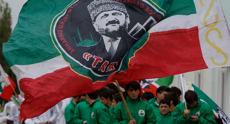 Члены юношеского клуба идут с флагами, на которых изображен Ахмат Кадыров. Фото: REUTERS/Maxim Shemetov
