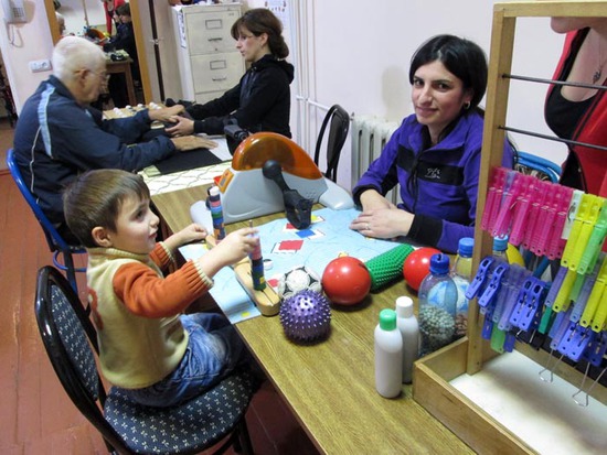Мать делает упражнение с сыном упражнения по развитию пальцев и развитию координации Мать делает упражнение с сыном упражнения по развитию пальцев и развитию координации
