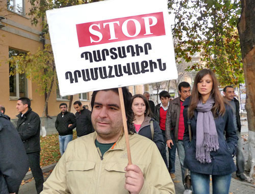 Участники акции протеста потребовали от властей Армении доработать реформу пенсионной системы. На снимке: один из участников акции с плакатом "STOP обязательным сборам". Ереван, 15 ноября 2013 г. Фото Армине Мартиросян для "Кавказского узла"