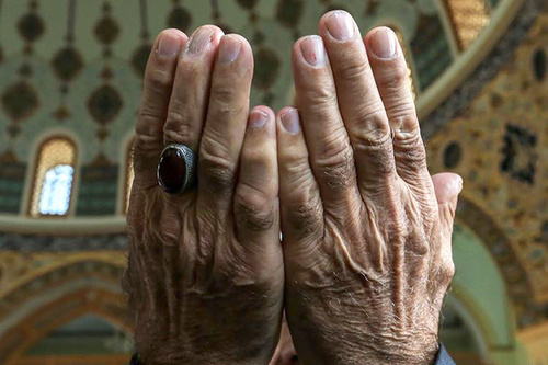 Руки верующего в молитвенном жесте. Фото Азиза Каримова для "Кавказского узла"