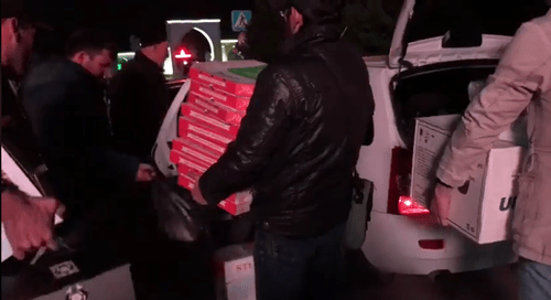 Активисты выгружают из машины вещи и еду для протестующих. Кадр видео Бекхана Хашагульгова.