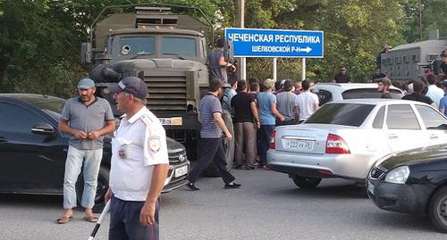 Силовики и участники схода в Кизляре под указателем Чечни. Фото Ильяса Капиева для "Кавказского узла"