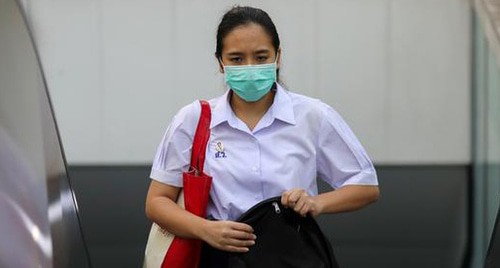 Девушка в медицинской маске. Фото REUTERS/Athit Perawongmetha