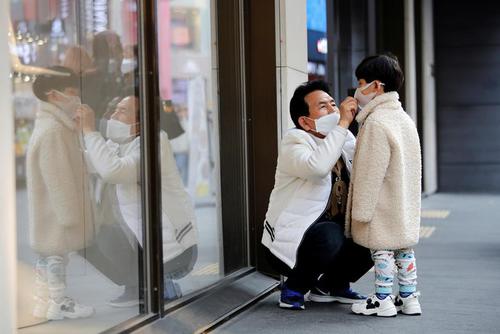 Мужчина и мальчик носят маски в торговом районе Мёндон в Сеуле, Южная Корея. Февраль 20, 2020. Фото: Reuters /Heo Ran
