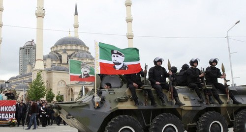 БТР с флагами Ахмата и Рамзана Кадыровых на фоне мечети имени Кадырова. Фото: REUTERS/Kazbek Basayev