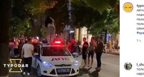 Девушка пробегает по крыше полицейской машины в Краснодаре. Кадр видео, опубликованного в Instagram-паблике "Туподар" https://www.instagram.com/p/CBIHbq-gKWu/ Девушка пробегает по крыше полицейской машины в Краснодаре. Кадр видео, опубликованного в Instagram-паблике "Туподар" https://www.instagram.com/p/CBIHbq-gKWu/