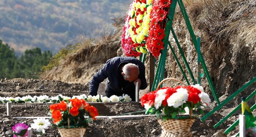 Мужчина скорбит на могиле павшего солдата, погибшего во время военного конфликта в Нагорном Карабахе, Степанакерт, 14 октября 2020 года. REUTERS/Stringer