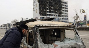 Мужчина рассматривает сожженый автомобиль на месте терракта. Грозный, 4 декабря 2014 г. Фото: REUTERS/Stringer 