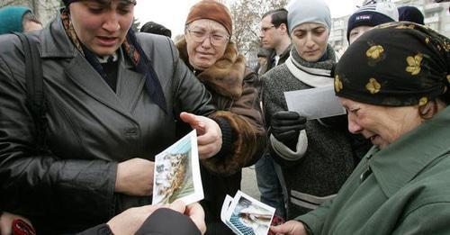 Родственники погибших во время атаки на Нальчик рассматривают фотографии. Нальчик. 29 ноября 2005 г. Фото: REUTERS/Viktor Korotayev