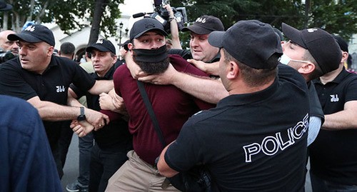 Сотрудник полиции задерживает участника акции протеста против проведения гей-парада в Тбилиси. 5 июля 2021 г. Фото: REUTERS/Irakli Gedenidze