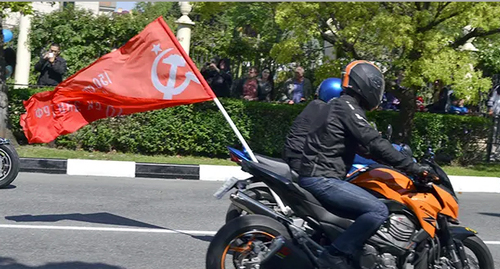 Мотоциклист с советским флагом Победы. Фото Светланы Кравченко для "Кавказского узла" 