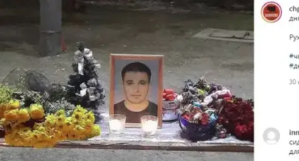 Цветы и свечи возле портрета Инала Джабиева. Скриншот со страницы «ЧП / Цхинвал» в Instagram.   https://www.instagram.com/p/CKlMRR1rjtq/