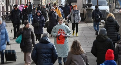 Лена Патяева (в пальто с надписью "Где Седа?") на улице Санкт-Петербурга с листовками об исчезновении Седы Сулеймановой. 8 марта 2024 года. Фото: Sota https://t.me/sotaproject/76335