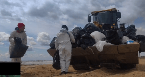 Волонтеры грузят собранные мешки на Бугазской косе мешки с мазутом и мусором. Скриншот фото из Telegram-канала "Мои слезы из мазута" от 12.04.25, https://t.me/mazuttears/1299.