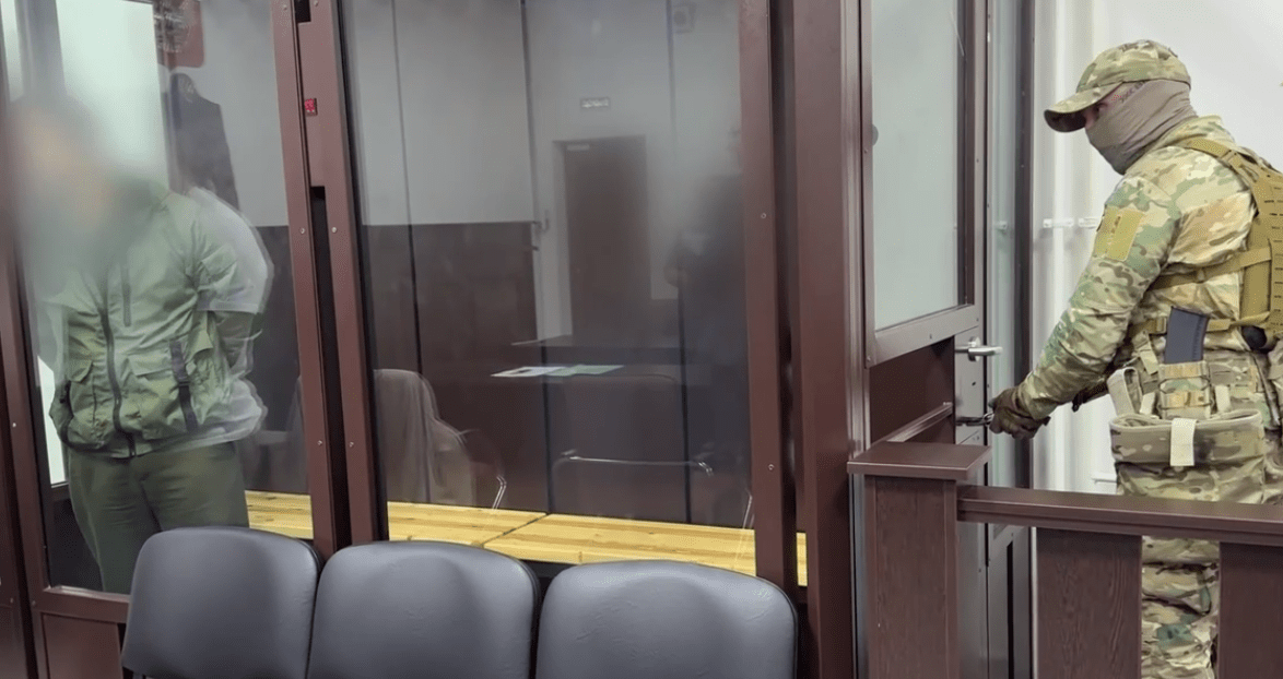 Бывший силовик (слева) и конвойный в зале суда. Стоп-кадр видео из Telegrram-канала управления СКР по Ингушетии от 07.06.25, https://t.me/su_skr06/3793