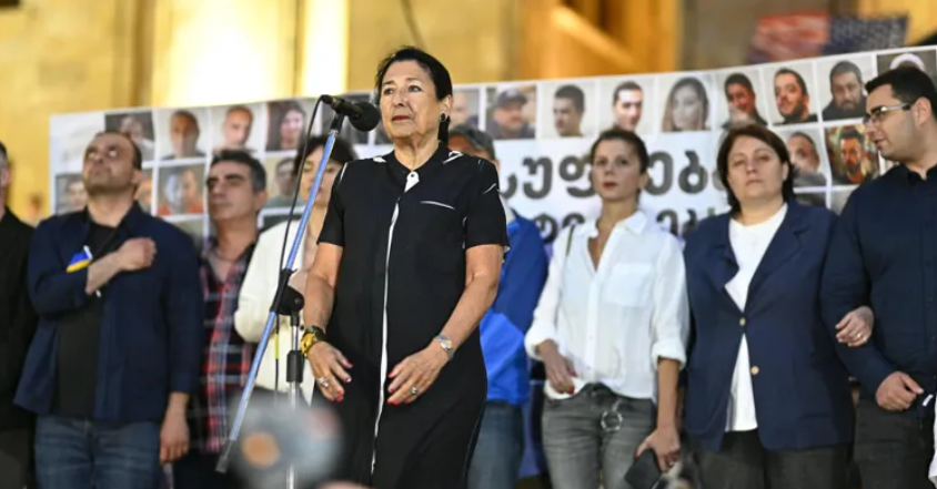 Саломе Зурабишвили у парламента Грузии. Вторая справа - Элене Хоштария. Скриншот фото "Интерпрессньюс" от 29.06.25, https://www.interpressnews.ge/ka/article/842578-salome-zurabishvili-gamarjveba-rezhimze-ar-mova-arc-archevnebshi-monacileobit-arc-shimshilobit-ertaderti-brzola-aris-ertobis-brzola-makvs-ertaderti-ambicia-rom-ertobit-kveqana-gadavarchinot