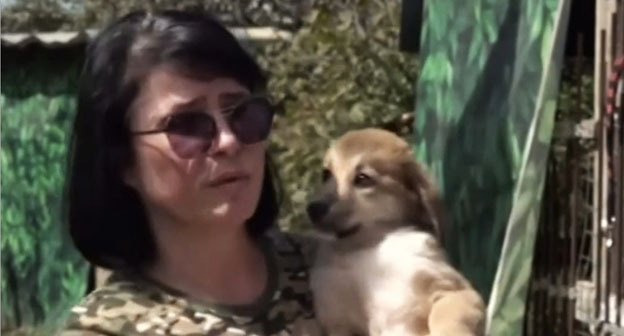Ирина Карпова со щенком Дафной на руках. Кадр видеосюжета телеканала "Россия Дагестан".