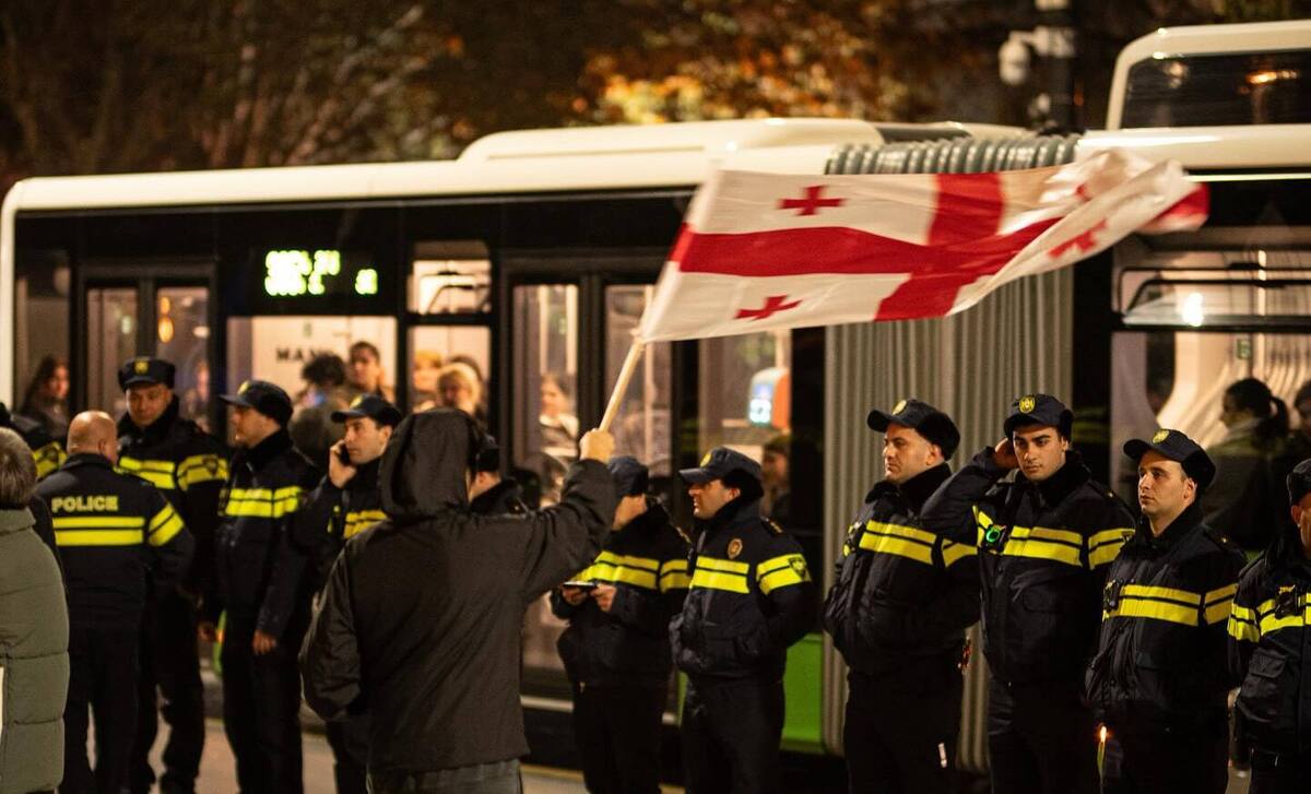 Демонстрант с флагом Грузии перед полицейскими на проспекте Руставели. Фото: Mindia Gabadze / Publika 