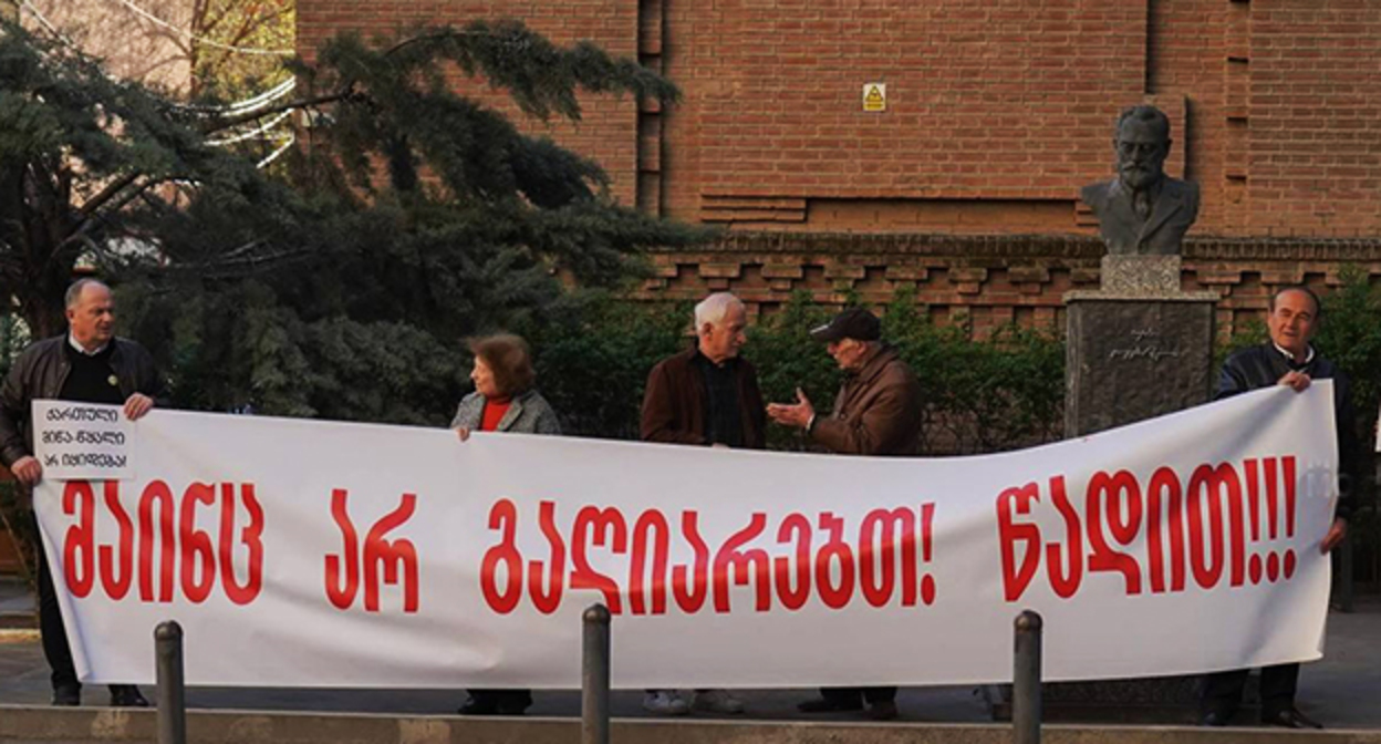 Протест у Минобразования Грузии. На баннере написано о том, что не будет признания (властям) и требование уйти. 16 апреля 2026 г. Фото: Mo Se/Video by Netgazeti
