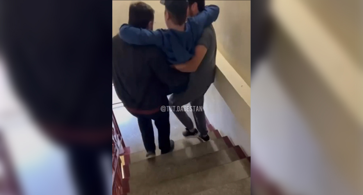 Двое мужчин несут на руках по лестнице пациента в махачкалинской больнице. Кадр из видео https://www.instagram.com/tut.dagestan/reel/Dc_gyg2qE_z (деятельность компании Meta (владеет Facebook, Instagram и WhatsApp) запрещена в России)