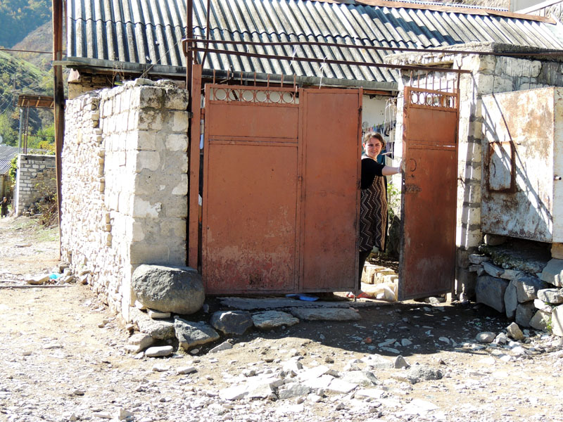 На звук нашей машины женщина выглянула из-за ворот. На звук нашей машины женщина выглянула из-за ворот.