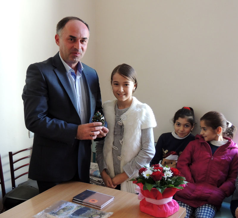 Диана, ученица 5 класса школы №3 дарит игрушку новогодней ёлки, сделанной ею.