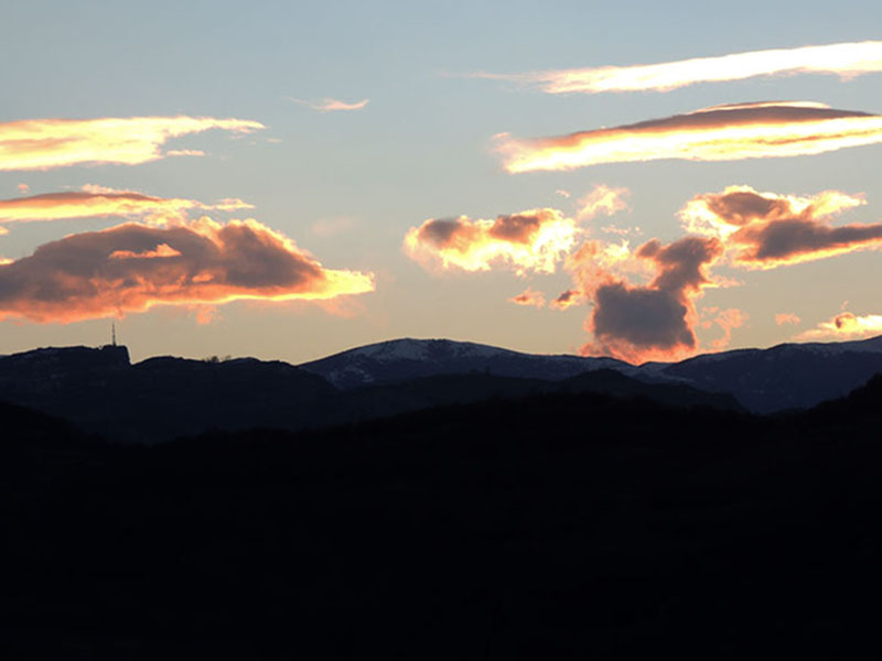 Последние лучи солнца окрашивают  облака в багряный цвет.