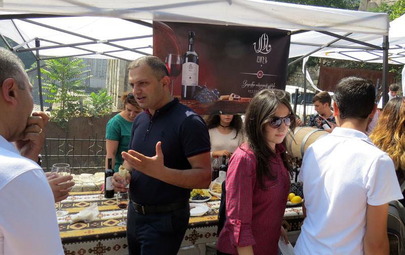 Мужчина делится с друзьями мнением о вкусе вина данного павильона.