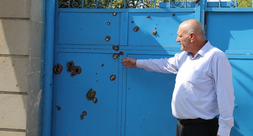 Житель  Барда показывает следы от осколков на воротах дома. Фото Азиза Каримова для "Кавказского узла"